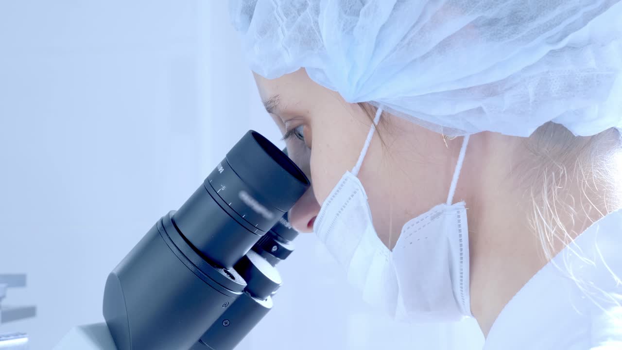 실험실에서 현미경을 사용하는 과학자