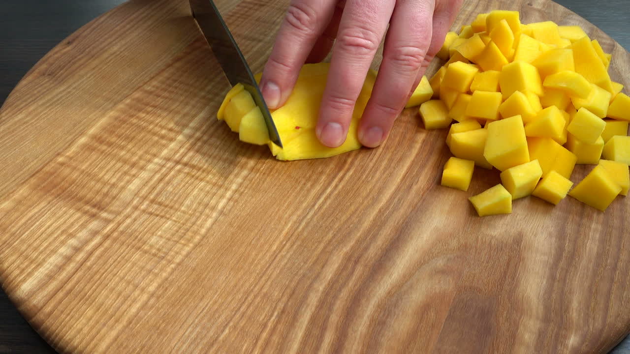 Kokken kutter biter av mango. Matlagingsopptak.