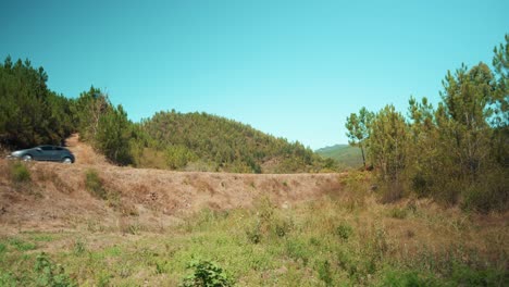 unidad de coche en la carretera rural entre colinas de árboles 4k