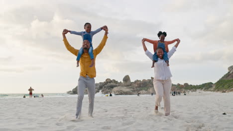 family, children on parents shoulders at beach