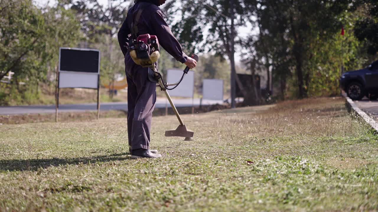 Person trimming grass with a string trimmer