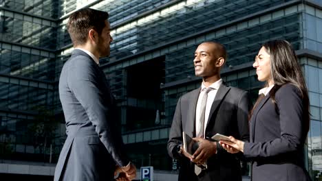 compañeros de negocios alegres hablando en la calle