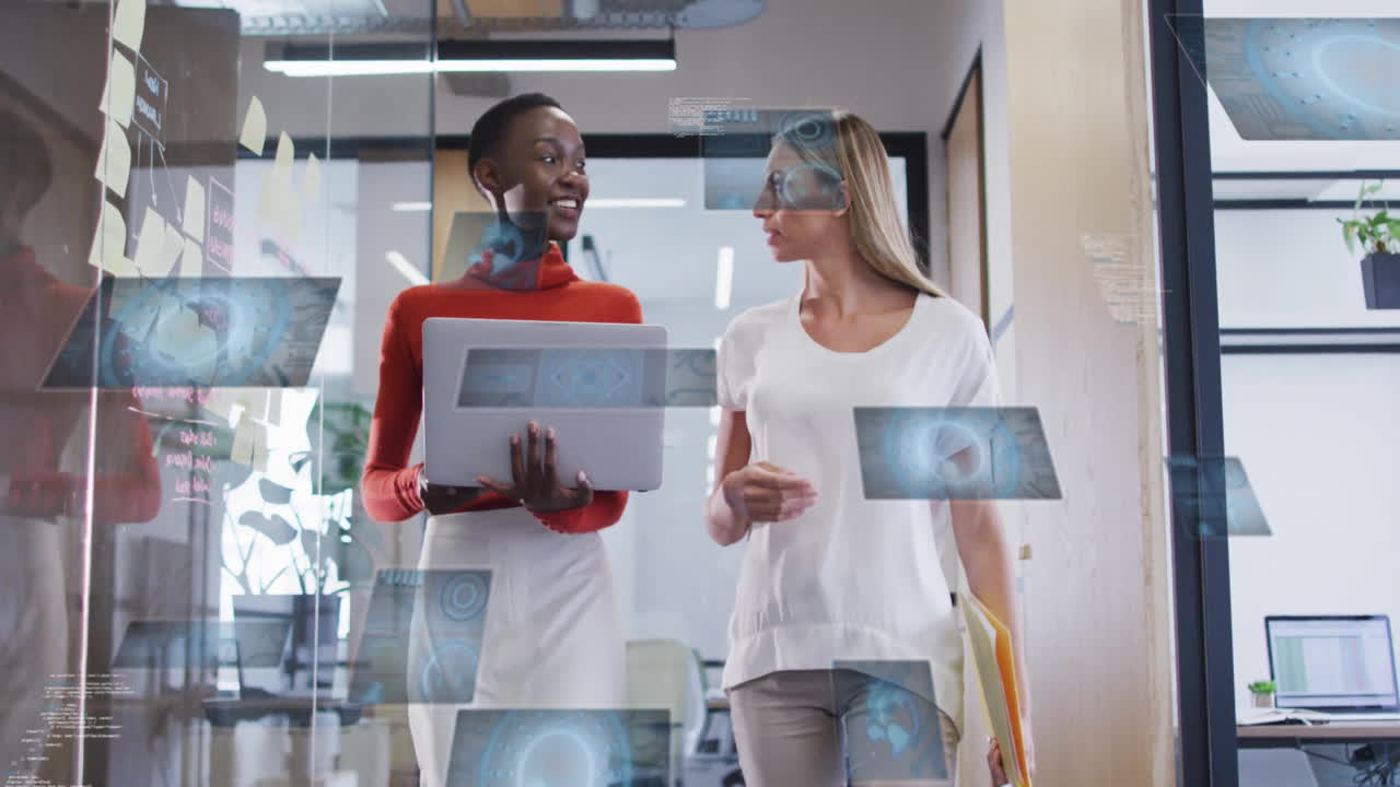 Two women walking in office with digital data animations surrounding them