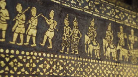 close-up detail of wat xieng thong gold stencil motif on a black wall in luang phrabang, laos