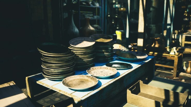 Vintage scene showing stacked porcelain on sunbleached table with deep shadows