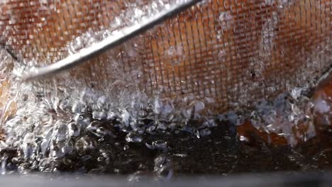 close up of donuts being deep fried in oil