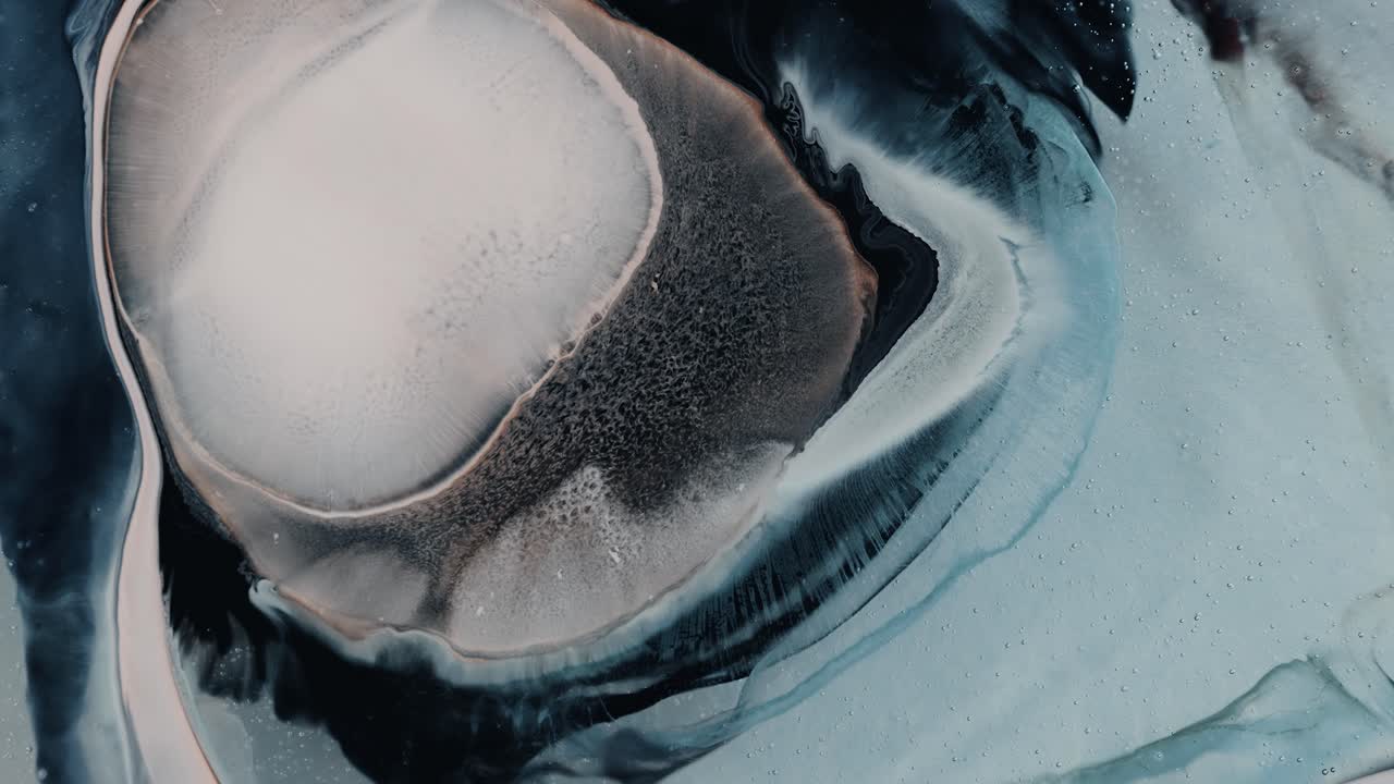 White Colored Ink Scattered On Multicolored Liquid