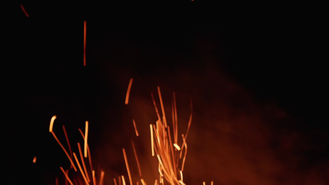 chispas de fuego voladoras sobre un fondo negro.
