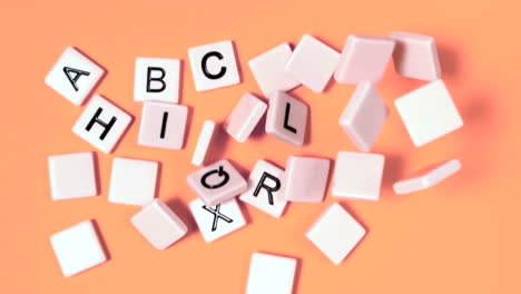 plastic letters bouncing and showing alphabet on orange surface