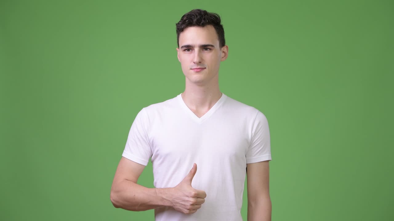 젊은 잘생긴 남자가 엄지손가락을 들고