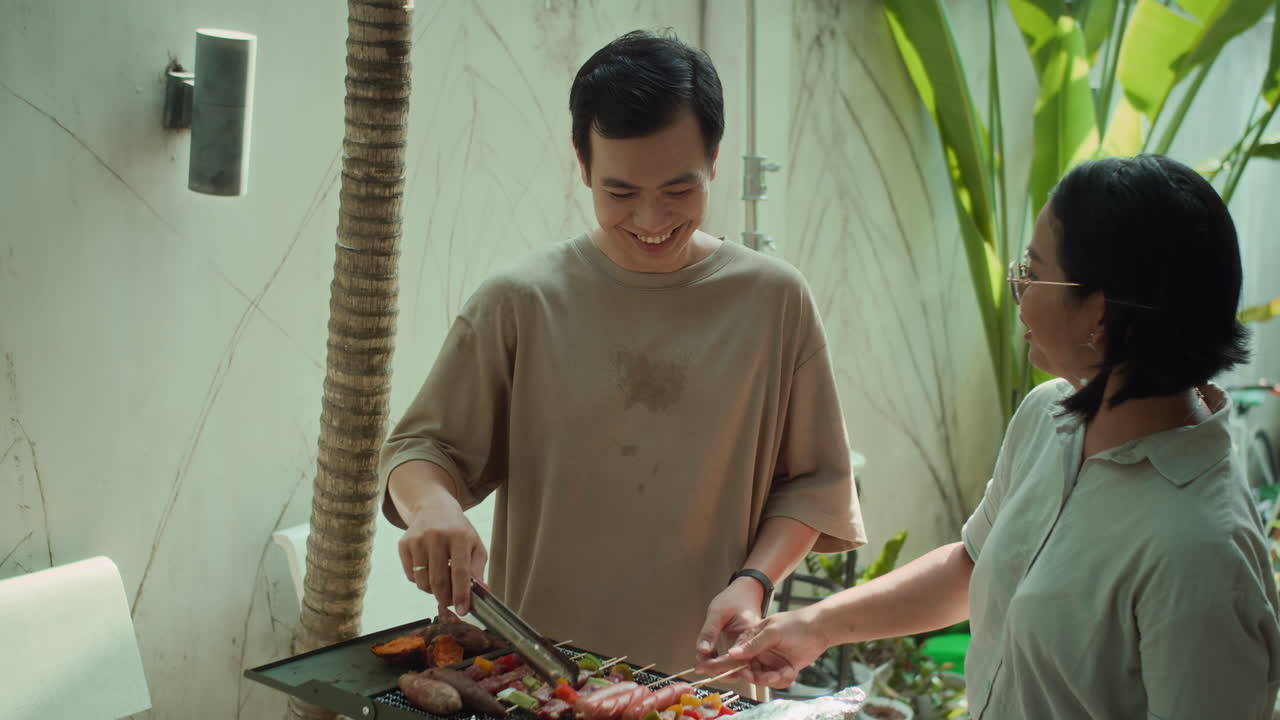 Cheerful Man and Woman Cooking Skewers on Grill