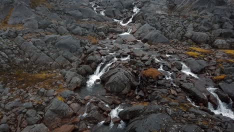 Aerial-view-of-a-long-waterfall-flowing-toward-the-sea-outside-Nuuk,-Greenland