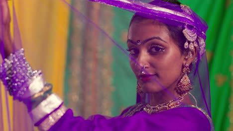 retrato de una bailarina de kathak que realiza un baile vestida con el vestido tradicional indio mirando a la cámara a través del tocado