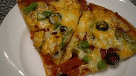 homemade pizza with two slices on plate at home