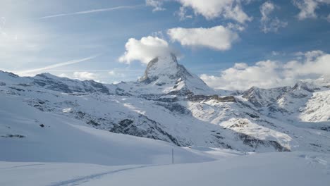 Toma-Panorámica-Lenta-Del-Paisaje-Montañoso-Cubierto-De-Nieve-Con-Matterhorn,-Alpes-Suizos-Famosa-Estación-De-Esquí-Del-Glaciar-Zermatt