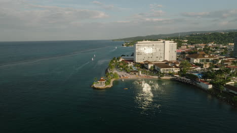 Muñeca-De-La-Hora-Dorada-En-Un-Complejo-De-Lujo-Con-Reflejos-De-Agua-De-Cristal-Reluciente-Frente-A-La-Costa-De-Jamaica