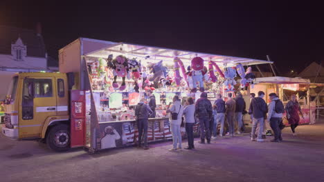 nighttime crowd enjoying a lively fair with plush toy machines in montrichard val de cher