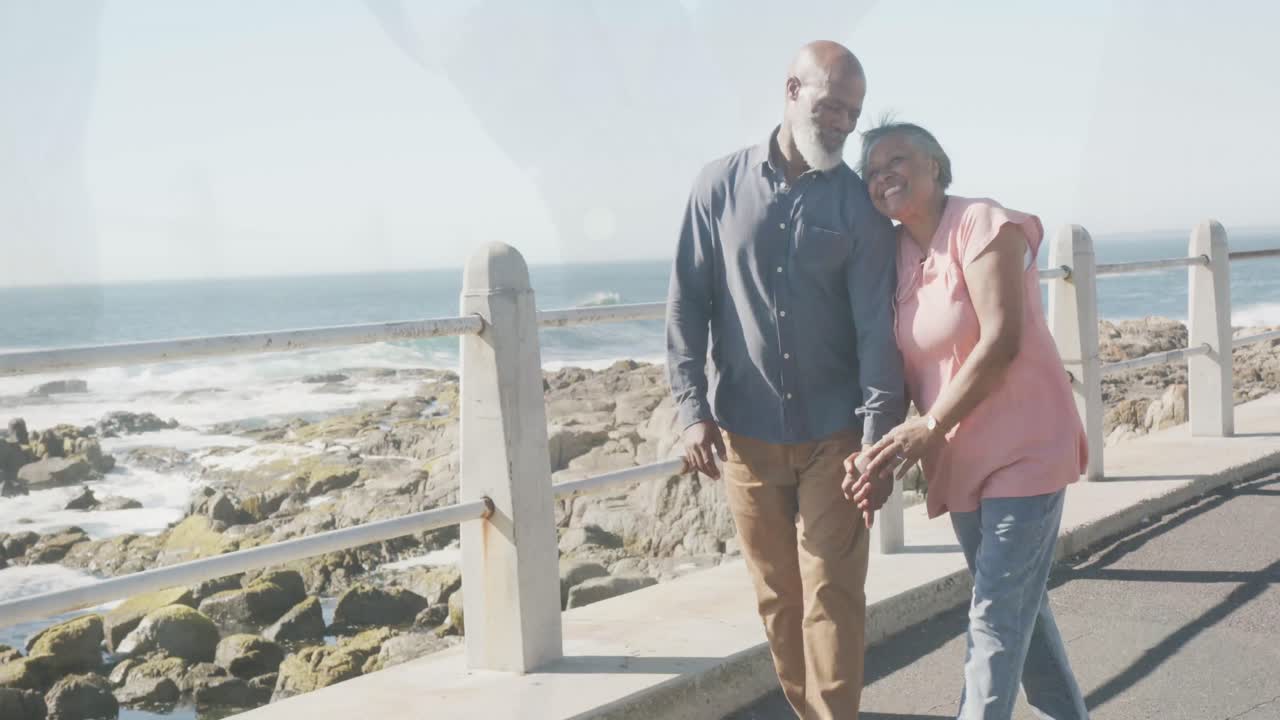 una feliz pareja de ancianos afroamericanos que pasan tiempo juntos en la playa, cámara lenta
