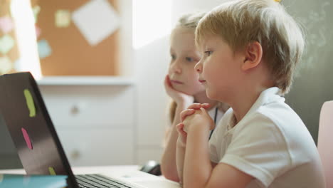 Ein-Paar-Kinder-Schauen-Sich-Gemeinsam-Zeichentrickfilme-Auf-Dem-Laptop-An