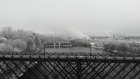 puente y presa del río en invierno rodeados de árboles cubiertos de escarcha