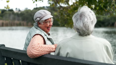 senior women laughing on a park bench