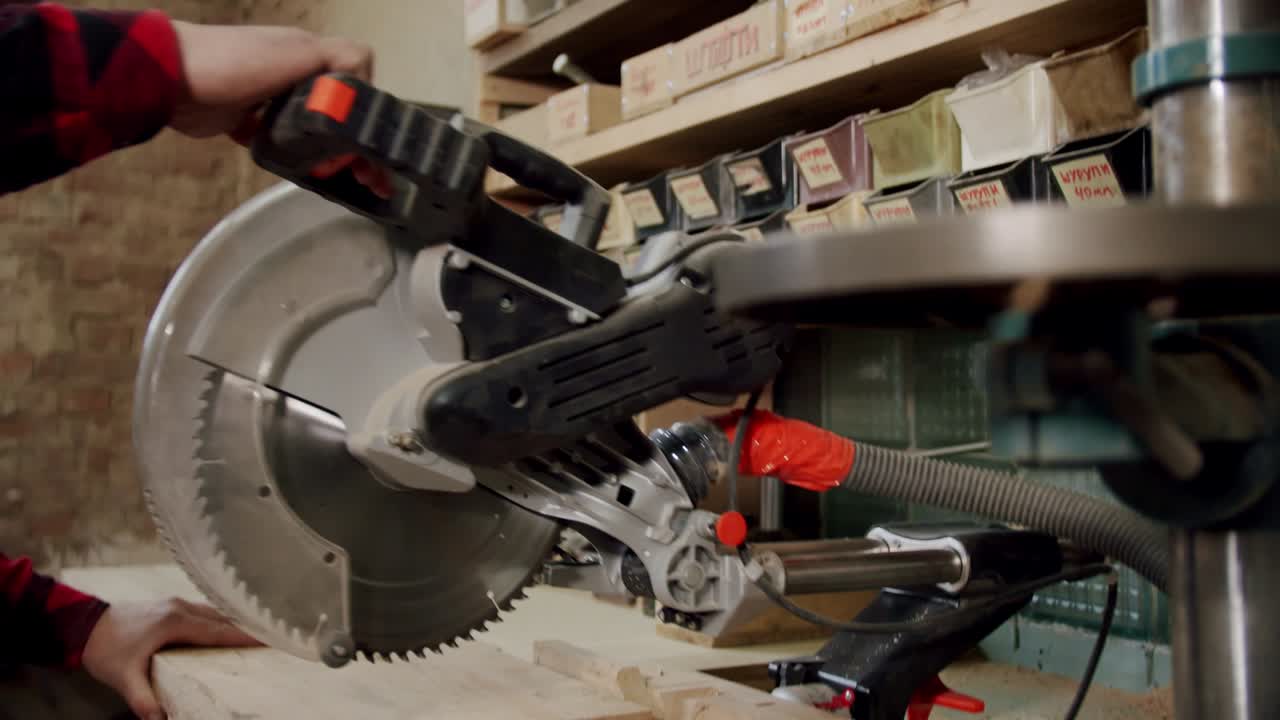 cámara lenta el maestro corta una tabla de madera con una sierra circular en el taller de carpintería de un pequeño fabricante de muebles.