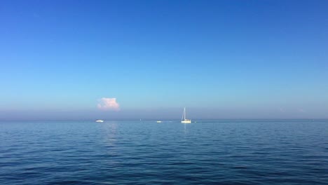wide shot of sailboats and motor boats on calm water on a beautiful summer day