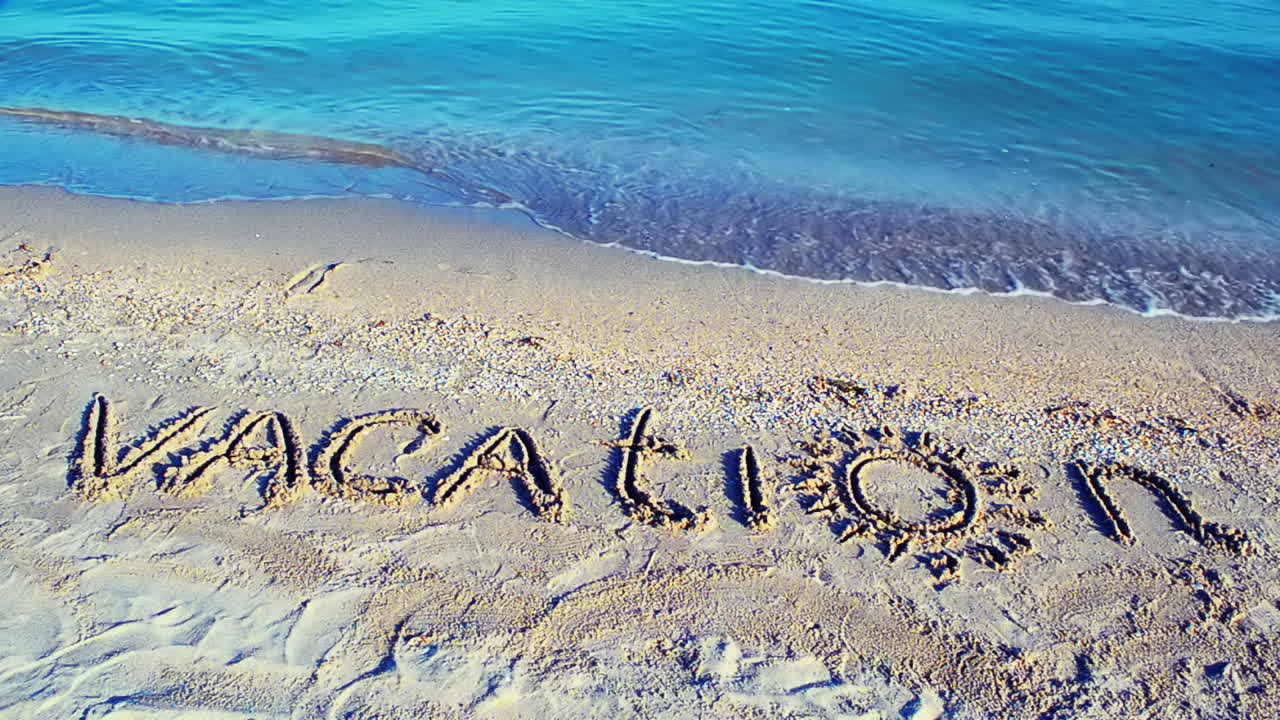 The inscription Vacation on sand. Inscription on sand