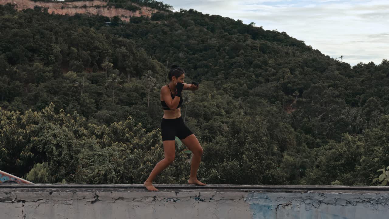 Woman practicing Muay Thai in a natural setting