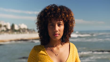 Woman-looking-at-camera-with-sea-in-background