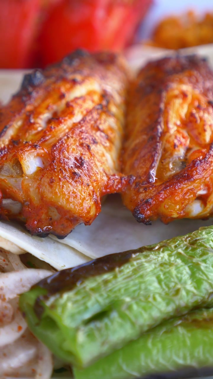 Primo piano di ali di pollo grigliate servite con verdure
