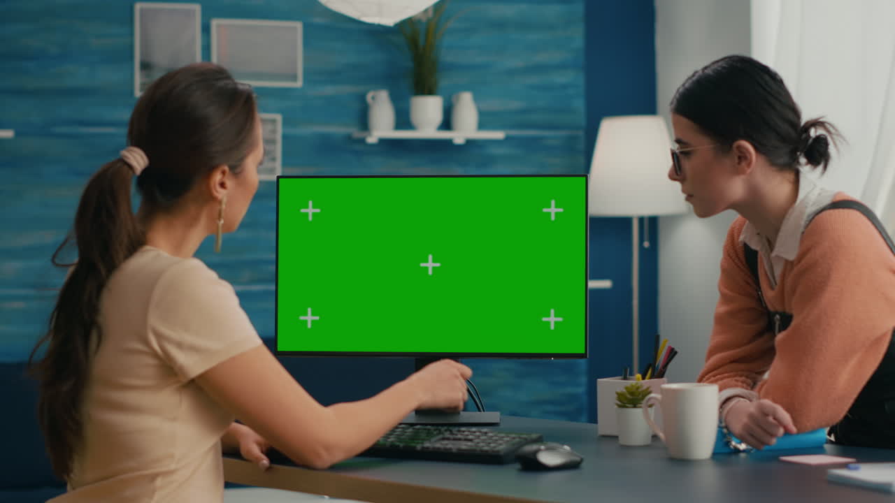 컴퓨터 녹색 스크린 앞에 앉아 있는 두 친구