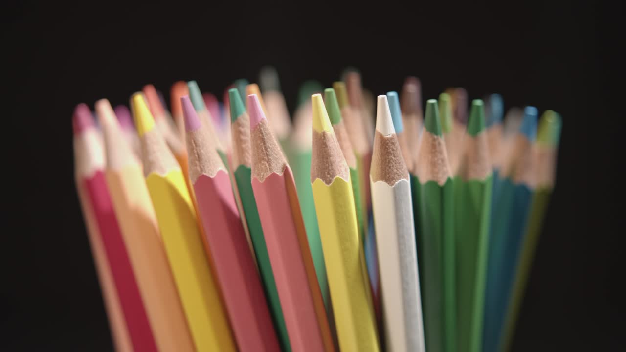 rotando lápices multicolores o lápices de tonos pastel de rotación lenta. los criones multicolores giran o giran en un círculo alrededor del eje central o vertical. resolución de 4k dci.