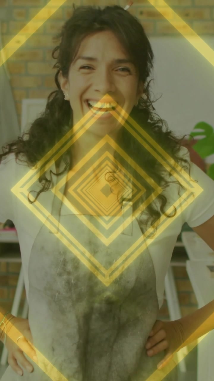 Donna che reagisce a una sovrapposizione di un diamante dorato pulsante, sorridendo, ridendo, mostrando orgoglio per il proprio mestiere in studio