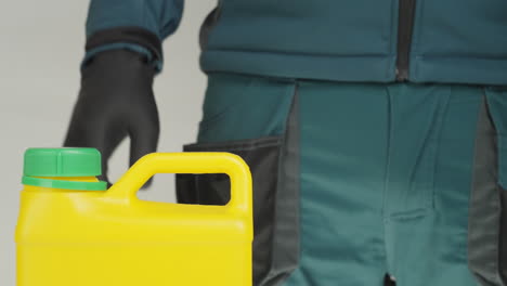 person in gloves opening a yellow container