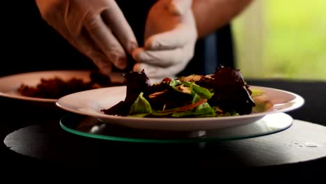 hands putting chopped almonds in the salad