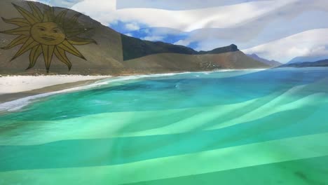 Digital-composition-of-waving-uruguay-flag-against-aerial-view-of-the-sea