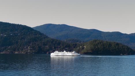 a view of a ferry sailing through howe sound with bowen island in the background in british columbia, canada