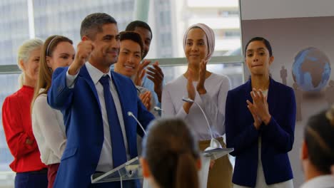 Businessman-standing-at-podium-with-colleagues-in-the-business-seminar-4k