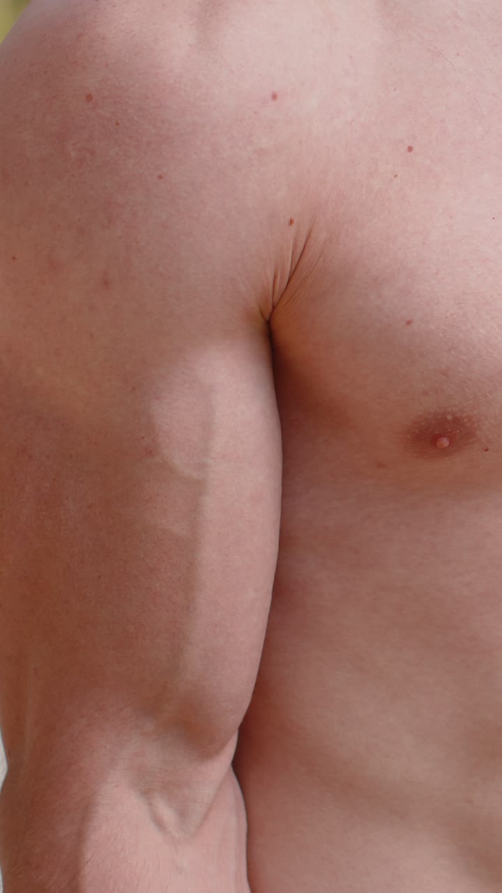 uomo atletico in primo piano che fa braccia sollevando pesi manubri esercizi pompando i muscoli del biceps del braccio