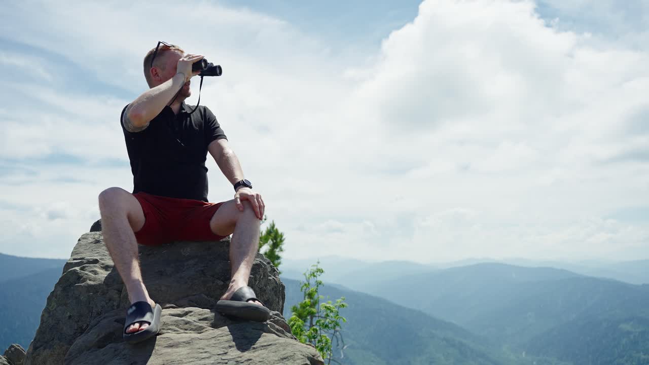 Man with Binoculars on Mountain Peak