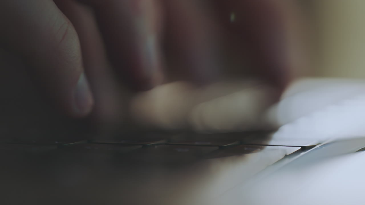 Close-up of hands typing on a laptop keyboard