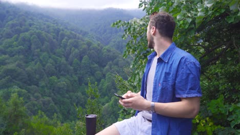 el hombre que está enviando mensajes por teléfono está en el bosque.