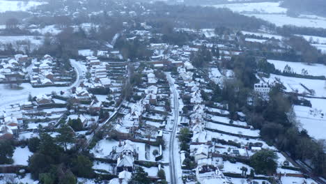 Imágenes-Aéreas-De-Drones-De-Casas-En-Inglaterra-En-Una-Mañana-Nevada-Con-Tejados-Cubiertos-De-Nieve-Y-Nieve-En-Las-Carreteras,-En-La-Ciudad-Inglesa