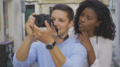 Aufgeregtes-Junges-Paar,-Das-Draußen-Fotos-Macht.