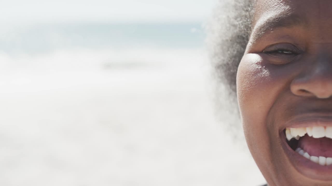 retrato de una feliz anciana afroamericana sonriendo en la playa, en cámara lenta, con espacio para copiar