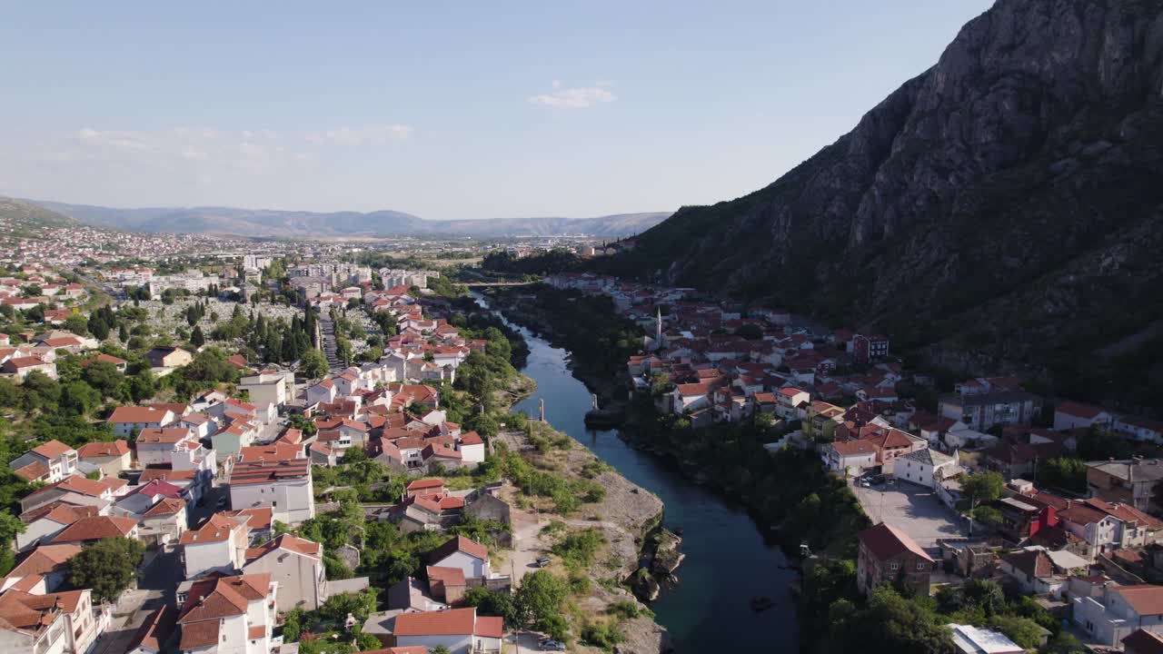 aerial: mostar, río serpenteando a través, enmarcado por montañas