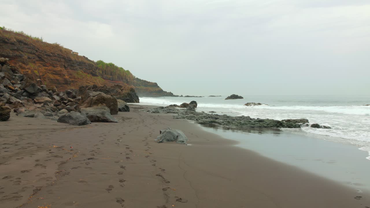 스페인 카나리아 제도의 테네리페에 있는 대서양의 바위 화산 해변에 있는 바다의 파도.