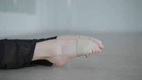 fit girl in black clothes performing contemporary. female dancer shows flowing motions, body and hands waves at white room. modern ballet dance choreography. young woman is moving smoothly