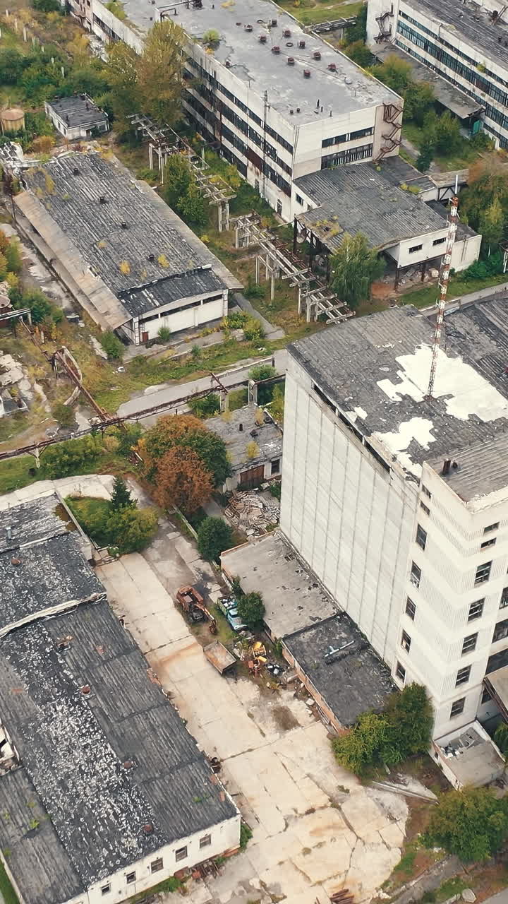 Aerial view of industrial destroyed city buildings. View from above of ruined and abandoned factory. Vertical video